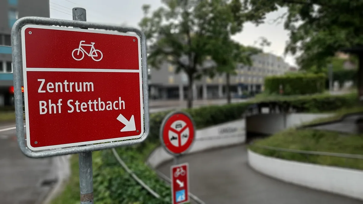 Ein Hinweisschild für Velofahrer vor einer Unterführung. 